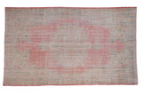 Vintage distressed hand-knotted Oushak carpet with faded pale raspberry medallion and seafoam green.