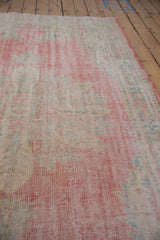 Softened pile and distressed texture of vintage Oushak in pale raspberry, ivory, and green.