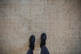 Distressed vintage Oushak carpet texture with worn pile and faded cream and seafoam patterns.