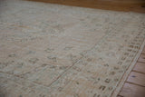 Distressed Oushak rug showing worn pile, visible foundation, and muted cream, brown, seafoam motifs.