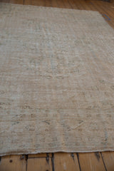 Distressed vintage Oushak rug showing worn pile texture and faint patterns.
