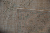 Distressed Oushak rug's worn cream and brown pile, showing its woven foundation and selvage.