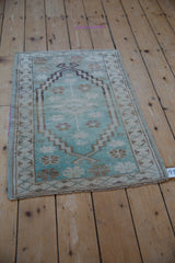 Distressed Oushak rug mat with muted mint green and traditional floral-geometric patterns.