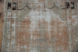 Close-up of distressed vintage Oushak rug showing exposed foundation and muted abrash colors.