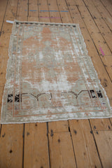 Distressed Oushak rug, extensive wear, visible foundation in sandalwood, faded blue, ivory.