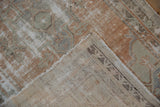 Vintage distressed Oushak rug corner revealing worn pile, tattered edge, and foundation back with markings.