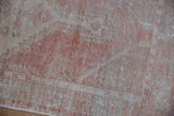 Distressed Oushak runner close-up, dusty blush, beige hues, mostly even wear to knot heads.