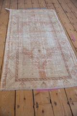 Angled perspective of a distressed Oushak runner, highlighting its faded medallion and overall wear.