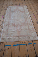 Angled view of a distressed vintage Oushak runner, showing its soft, time-worn patina.