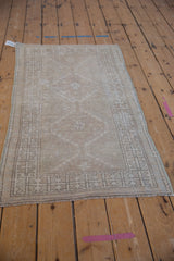 Vintage distressed Oushak rug corner, showing geometric blossom border and even wear.