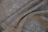 Vintage distressed Oushak rug close-up, showcasing soft beige tones and worn texture.