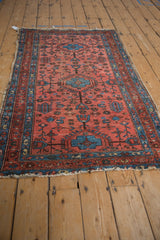 Vintage Lilihan rug with raspberry red field, sapphire blue pinwheels, and boteh border pattern.