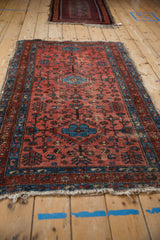 Worn raspberry red field of a vintage Lilihan rug with sapphire blue geometric patterns.