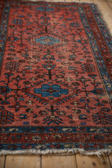 Worn raspberry red field, sapphire blue geometric plant motifs on this vintage Lilihan rug.