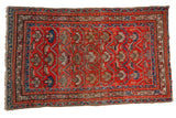 Vintage hand knotted Hamadan rug with geometric palmettes, figures, and animals in tomato red, sky blue, and sand tones.