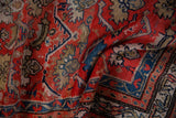 Textured pile and geometric floral palmettes of a vintage Hamadan rug in red, blue, and sand.