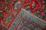 Vintage hand-knotted Hamadan rug displaying red geometric pile, fringe, and striped woven back.