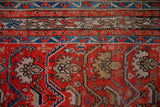 Detail of a vintage Hamadan rug showing geometric borders and red field with sand palmette cross-sections and bird motifs.