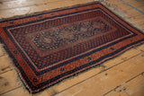 Vintage Beshir rug corner with terracotta meandering vine border, indigo seed motif, visible knot heads.