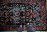 Vintage Lilihan rug's navy and raspberry red field, showing sprawling floral motifs and pile wear.