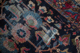 Vintage Lilihan rug detail showing navy field, raspberry and sky blue blossoms, with visible knot heads.