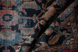 Folded vintage Lilihan rug, worn pile texture revealing navy field and multi-hued sprawling florals.