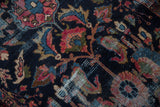 Close-up of vintage Lilihan rug showing floral blossoms, navy blue ground, and visible foundation.