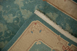 Jade green scrolling vinery pile and sand-colored tightly woven rug back with fringe.