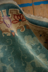 Soft jade green and sand Rococo vinery on a rolled Chinese Nichols rug runner.