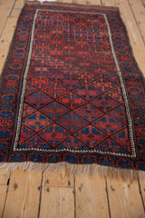 Vintage Belouch runner with madder red, sapphire blue diamond lattice, charcoal border, and natural fringe.