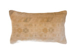 Vintage hand-knotted Turkish rug fragment pillow with faded beige geometric pattern.