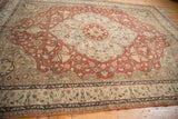 Distressed vintage Sparta carpet, scalloped red field with madder rust, sand, and blue patterns.