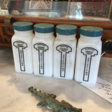 Vintage Griffith's milk glass spice jars with teal lids and black graphic labels.
