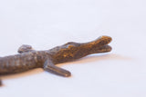 Hand-cast bronze crocodile with aged, textured surface on its head and body.
