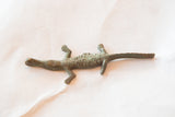 The textured body and aged finish of the African bronze crocodile casting.