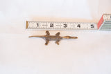 Handmade African bronze lizard casting measured against a tape showing its 3.5 inch length.