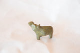 Angled view of a vintage African bronze hippo casting with textured green patina.