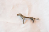 Vintage African bronze lion casting, showing its full length and aged texture.