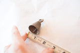 Measuring a small vintage African bronze bell to show its 1.5-inch scale.