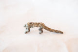 Side view of the vintage bronze pangolin showing the texture of its overlapping scales.