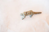 Detailed side view of the vintage bronze pangolin casting highlighting its weathered, scaly texture.