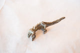 The scaly texture and long, arched body of the vintage bronze pangolin casting.