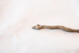 Sculpted head of a vintage bronze snake casting with raised eyes and a textured patina.