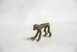 Vintage bronze monkey gold weight on all fours, showing its textured spine and patina.