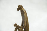 Side profile of the vintage monkey sculpture showing its slender torso and textured bronze patina.