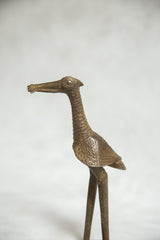 Profile detail of a bronze African bird sculpture with a ribbed neck and stylized eye.
