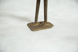 The hand-cast bronze feet and solid square base of the vintage African bird sculpture.