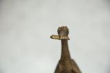 Close-up of the cast bronze fish held in the beak of the African bird sculpture.