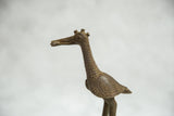 Textured bronze fishing bird sculpture head with prominent triple horn details.