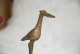 Close-up of vintage African bronze bird sculpture's textured neck and spiral eye.